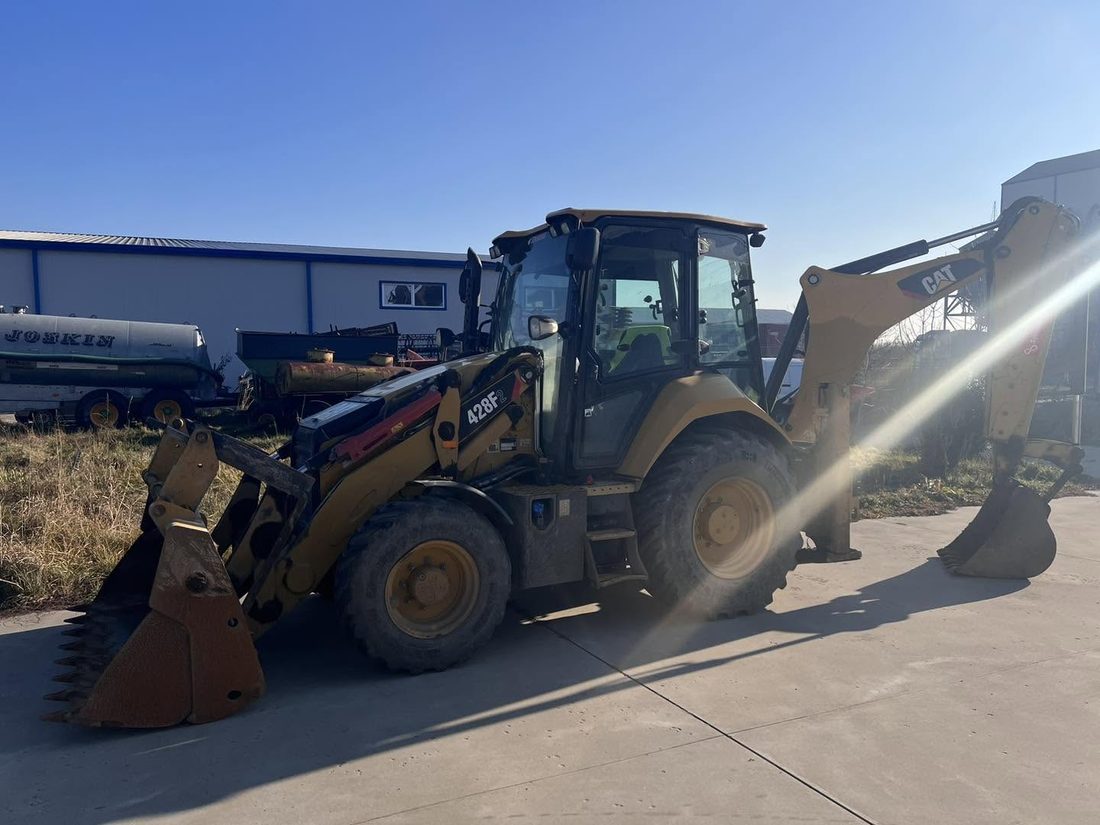 Buldoexcavator Caterpillar 428F, în curtea de service